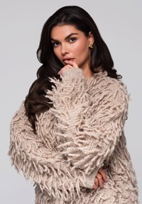 Beige, oversized svetr s texturovaným, chlupatým designem a ribovanými manžetami. Měkká pletená látka s uvolněným siluetou.