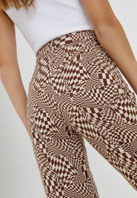 Hoge taille broek in een bruin en crèmekleurig ruitpatroon, met een aansluitend ontwerp en een gladde textuur.