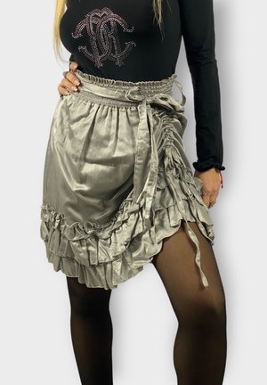 Falda de satén gris con dobladillo acampanado, con cintura ajustable y diseño en capas. Textura suave con un acabado brillante.