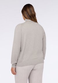 Pullover grigio chiaro a maniche lunghe con collo alto, orlo a coste e tessuto morbido, mostrato da dietro con pantaloni chiari abbinati.