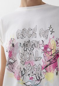 White cotton t-shirt featuring a graphic print with pink, yellow splashes and black outlines, text reading "ROCK ON WITH SCALPERS," and small studs.