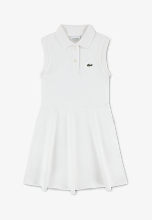Abito bianco senza maniche con colletto polo, dotato di una patta con bottoni e logo Lacoste verde sul petto. Tessuto liscio ed elastico.