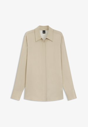 Beige overhemd met lange mouwen, verborgen knopen, spitse kraag en manchet mouwen, plat weergegeven tegen een witte achtergrond.