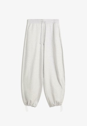 Pantaloni della tuta grigi chiari con vita elastica, coulisse, tasche laterali e polsini elastici arricciati su uno sfondo bianco.