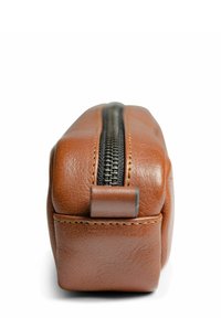 Hnedá kožená perá na ceruzky s textúrovaným povrchom, horizontálny čierny zips a žlté šitie pozdĺž okrajov. Kompaktný obdĺžnikový tvar.