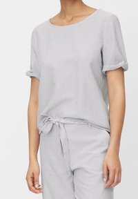 Haut rayé gris et blanc, doté de manches courtes avec revers retroussés et d'un ourlet noué à la taille, confectionné dans un tissu léger.