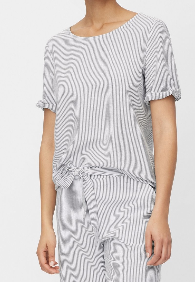 Haut rayé gris et blanc, doté de manches courtes avec revers retroussés et d'un ourlet noué à la taille, confectionné dans un tissu léger.