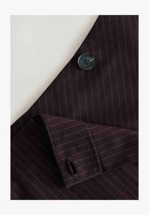 Maroon-raita kankaan, joka sisältää mustan napin ja räätälöidyn hihansuun. Sisältää hienoja pinstripes-viivoja ja ommellun napinreiän yksityiskohdan.