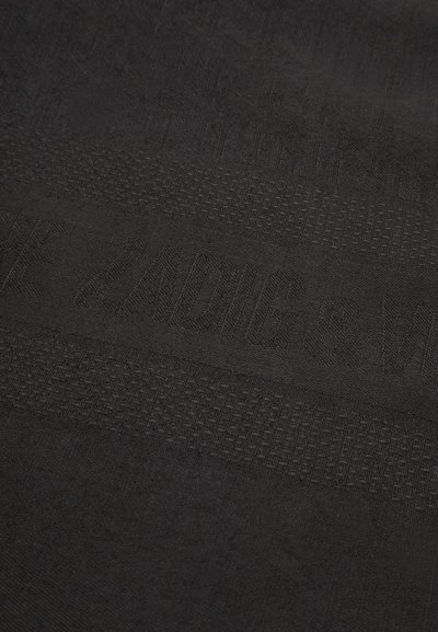 Crni materijal s teksturiranim uzorcima i istaknutim dizajnom logotipa. Glatka tekstura s različitim uzorcima tkanja za dubinu i vizualni interes.