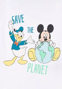 Witte t-shirt met daarop Mickey Mouse die een globe vasthoudt en Donald Duck. De tekst luidt "RED DE AARDE" in het groen. Dikkere cartoonontwerp met levendige kleuren.
