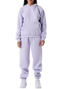 Paarse hoodie en trainingsbroeken set gemaakt van zacht materiaal, met een kangoeroezak, ribgebreide manchetten en bijpassende kleuraccenten.