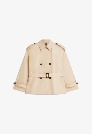 Bež dvojno zapet plašč z črnimi gumbi, pasom v pasu, ramenskimi trakovi in zapetimi manšetami, prikazan na ravni beli podlagi.