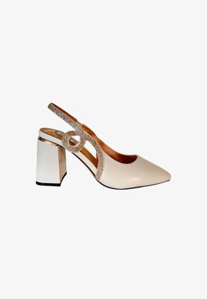 Décolleté slingback beige con punta affilata, cinturino decorato con cristalli e tacco a blocco bianco spesso. Texture liscia con accenti scintillanti.