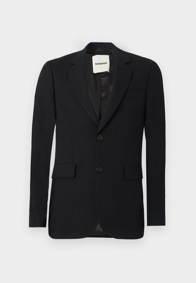 Blazer negru cu țesătură netedă, rever în formă de evantai, două buzunare frontale și două butoane. Dispune de un interior satinat și eticheta brandului în interior.