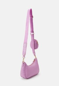 Sac à main rose de forme arrondie, texture rembourrée et quincaillerie dorée. Comprend une bandoulière détachable et une petite pochette attachée.