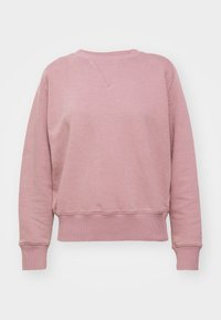 Różowa bluza z miękkiego materiału, z prążkowanym okrągłym dekoltem, długimi rękawami i lekko skróconym dołem, z wszytymi rękawami i detalami szwów.