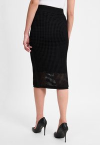 Schwarzer Strick-Bleistiftrock mit strukturiertem Muster, geripptem Bund und einer Länge bis zur Mitte der Waden, versehen mit einem durchsichtigen Abschnitt am Saum.