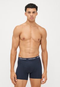 Navyblaue Boxershorts mit einem markierten Bund, die eine enge Passform und einen weichen, dehnbaren Stoff bieten. Das Design hat keine sichtbaren Muster oder Akzente.