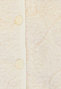 Witte fleece stof met een gestructureerd oppervlak, met een rechte sluiting met grote crèmekleurige knopen in het midden.
