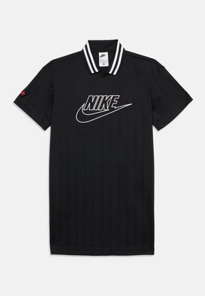 Polo Nike noir avec col rayé blanc, grand logo blanc Nike sur la poitrine et petite étoile rouge sur la manche gauche.