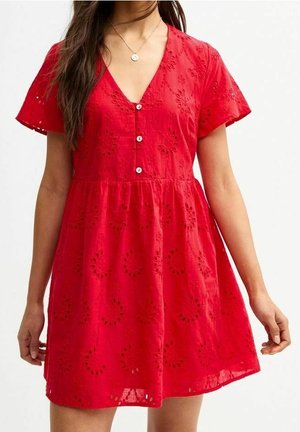 Robe rouge en tissu texturé, avec des manches courtes, un col en V, une fermeture à boutons à l'avant et des motifs floraux découpés tout au long.
