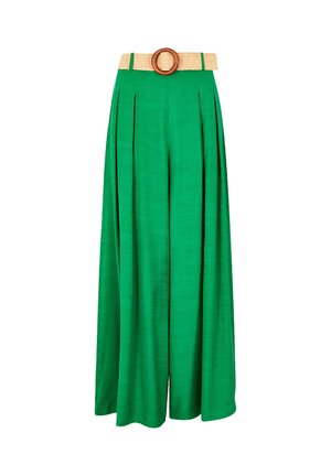 Pantaloni larghi verdi con pieghe, dotati di una cintura beige testurizzata con una fibbia in legno circolare. Tessuto morbido e silhouette fluida.