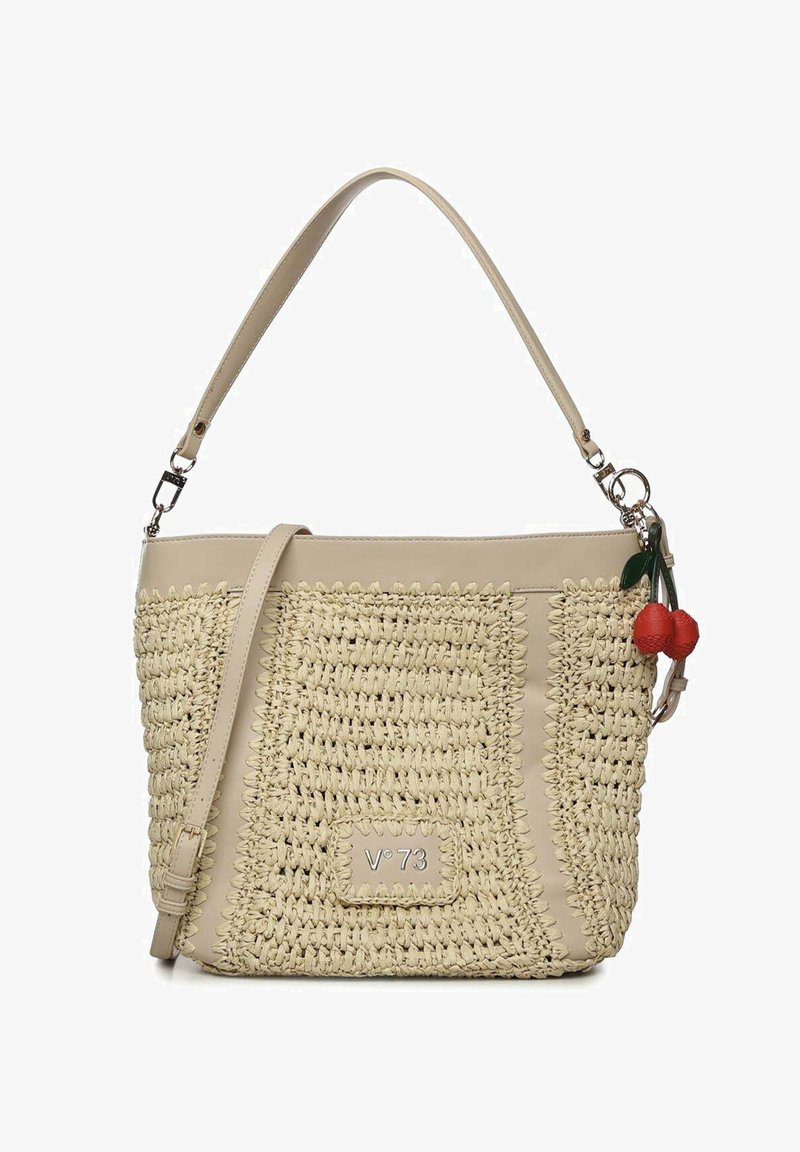 Borsa intrecciata beige con rifiniture in pelle, tracolla regolabile e due ciondoli rossi a forma di ciliegia appesi di lato.