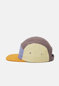Casquette multicolore avec un design jaune, brun, violet et orange, munie d'un bec plat et d'une sangle arrière ajustable. Tissu texturé avec des trous de ventilation.