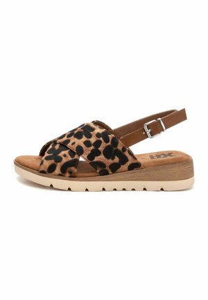 Sandali con stampa leopardata, dotati di fasce incrociate in morbido suede, dettagli in pelle marrone, cinturino alla caviglia regolabile e suola beige chiaro con texture antiscivolo.