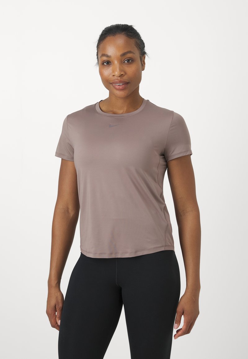 Korte mouwen, aansluitend sporttop in licht mauve, gemaakt van een soepele, rekbare stof. Bevat een klein, donker logo op de borst.