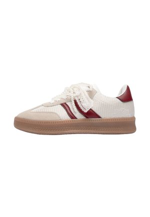Des baskets avec une tige en maille beige, des rayures en daim rouge et une semelle en caoutchouc brun texturé. Lacets décoratifs avec des accents ressemblant à des perles.