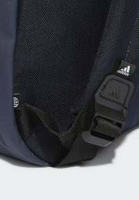 Zaino blu navy con tessuto testurizzato, una tracolla nera regolabile e una chiusura in plastica con il logo Adidas.