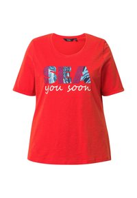 Červené bavlněné tričko s kulatým výstřihem. Na tričku je grafický text "SEA" v modré a "you soon" v bílé, s texturou na písmenech.