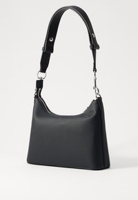 Μαύρη τσάντα ώμου κατασκευασμένη από λείο συνθετικό υλικό. Διαθέτει καμπύλο κλείσιμο με φερμουάρ και αποσπώμενο λουρί με μεταλλικές �λεπτομέρειες.