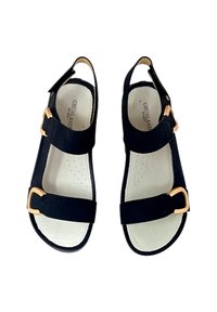 Sandali neri in suede con due cinturini regolabili, fibbie color oro e suole imbottite. Suola piatta e design con tallone aperto.