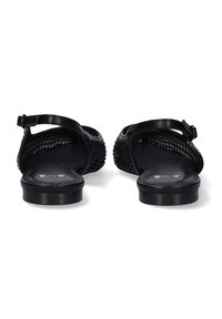 Sandalias negras con un diseño de malla en los laterales, correa ajustable en el tobillo, tacón plano y detalles texturizados en la superficie superior.