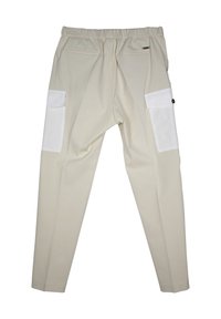Beige broek met een rekbare tailleband, voorzien van twee witte cargozakken aan de zijkanten en een knoopdetail op één zak. Vlotte textuur.
