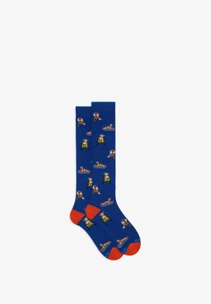 Blaue Socken mit roten Akzenten, die ein Hundemuster zeigen, auf dem Hunde in verschiedenen Posen abgebildet sind, aus einem weichen, dehnbaren Material gefertigt.