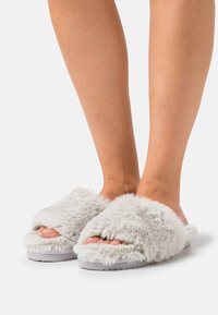 Grey fluffy slide slippers with an open toe design, soft texture, and a thick sole, providing comfort and warmth.