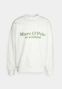 Sweat-shirt blanc avec un col rond et des manches longues. Présente un texte brodé en vert : "Marc O'Polo EST. IN STOCKHOLM." Texture lisse.