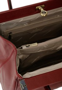 Borsa a tracolla rossa in pelle con esterno testurizzato, dotata di fodera beige e un scomparto con zip; include un accento in metallo dorato.