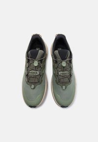 Zapatillas deportivas verdes con upper texturizado, cordones elásticos, cuellos acolchados y una suela de color gris claro. Presentan las áreas de los dedos y el talón reforzadas.