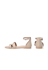 Flache Sandalen aus lightbeige Leder, mit einem Knöchelriemen, offener Spitze und zwei horizontalen Ausschnitten an der oberen Seite zur Belüftung.