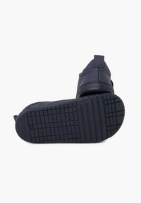 Tmavě modré nazouvací boty z hladké kožené svrchní části, s texturovanou gumovou podrážkou a robustním vzorkem pro lepší přilnavost. Minimalistický design s bočními pružnými akcenty.