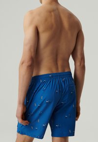 Niebieskie kąpielówki z elastycznym pasem, wzorem samolotów, lekkiego materiału i małą kieszonką z boku.