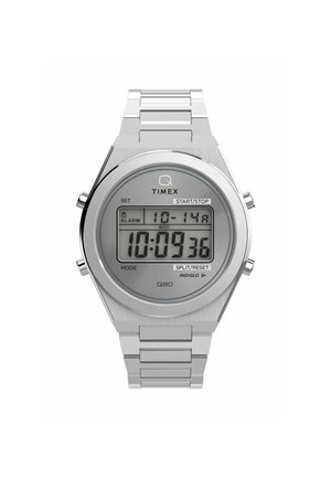 Montre numérique Timex Q80 avec un boîtier et un bracelet en acier inoxydable argenté, grand écran LCD, boutons marqués et fonction 'Indiglo'.