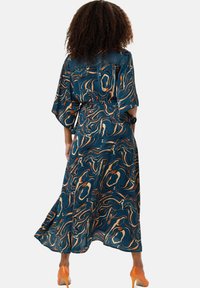 Long, flowing dress with a blue and orange marble pattern, short sleeves, and a cinched waist. Smooth fabric and ankle-length design.