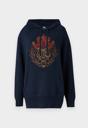 Vihreä tummansininen huppari, joka on valmistettu pehmeästä kankaasta ja jossa on näkyvä kirjailtu logo, jossa on kruunu ja laakerisymboleja. Mukana on kenguru-tasku.