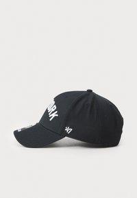 Black baseball cap made of fabric with a curved brim, featuring white "NEW YORK" embroidery on the front and a small logo on the side.