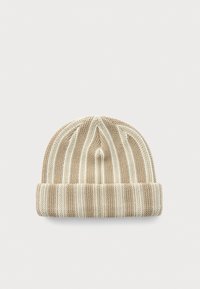 Beige gebreide beanie met witte verticale strepen en een omgeslagen rand, plat gelegd op een lichtgrijze achtergrond.